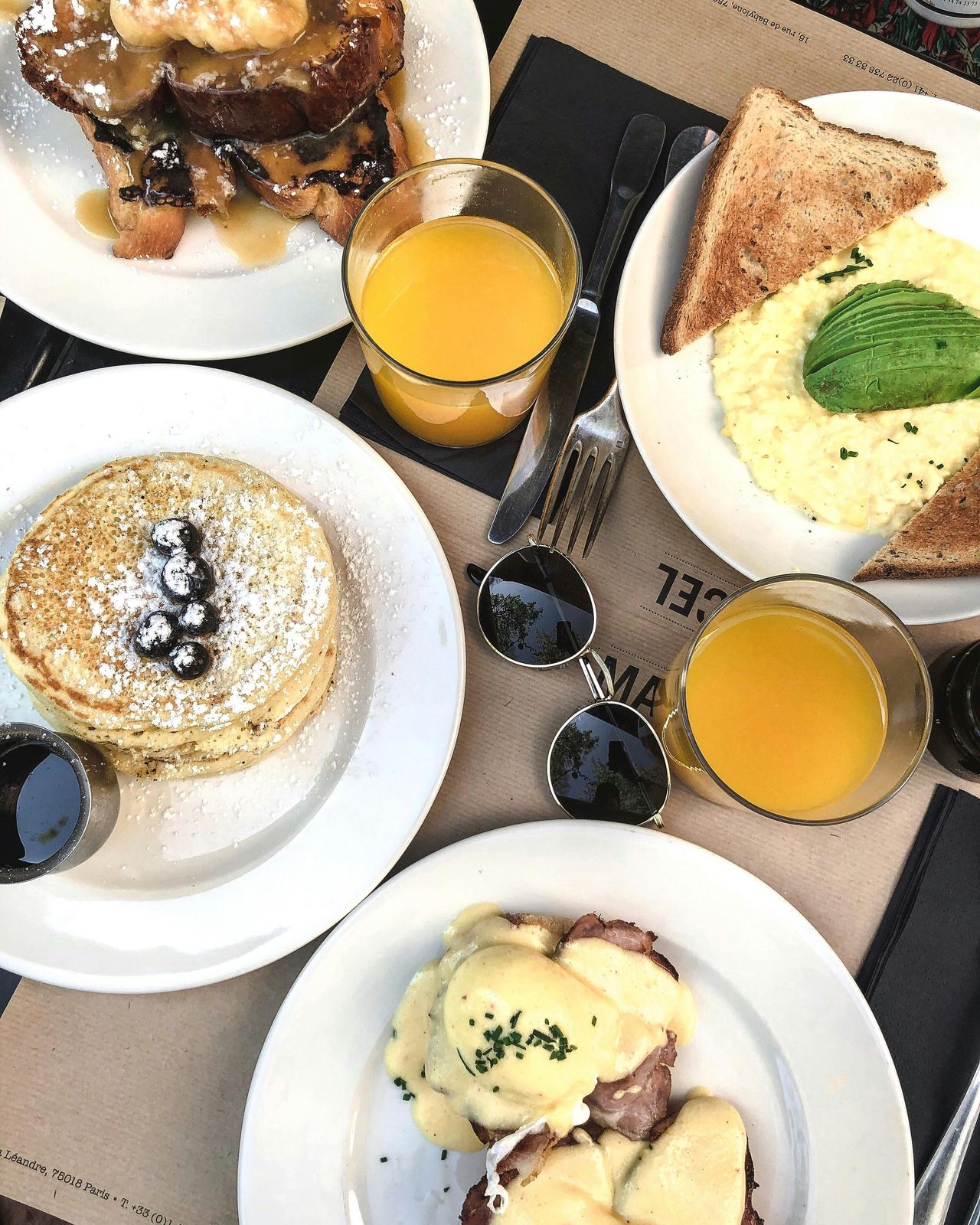 Breakfast spread with pancakes, eggs and orange juice
