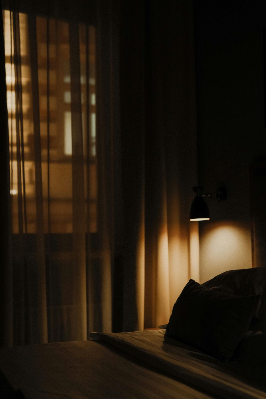 Bedroom softly lit by a bedside lamp